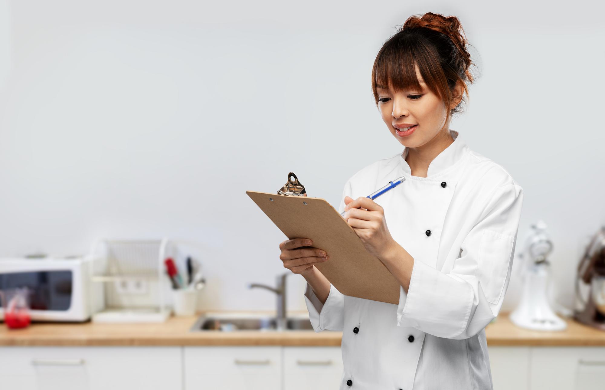 chef with clipboard reviewing inventory